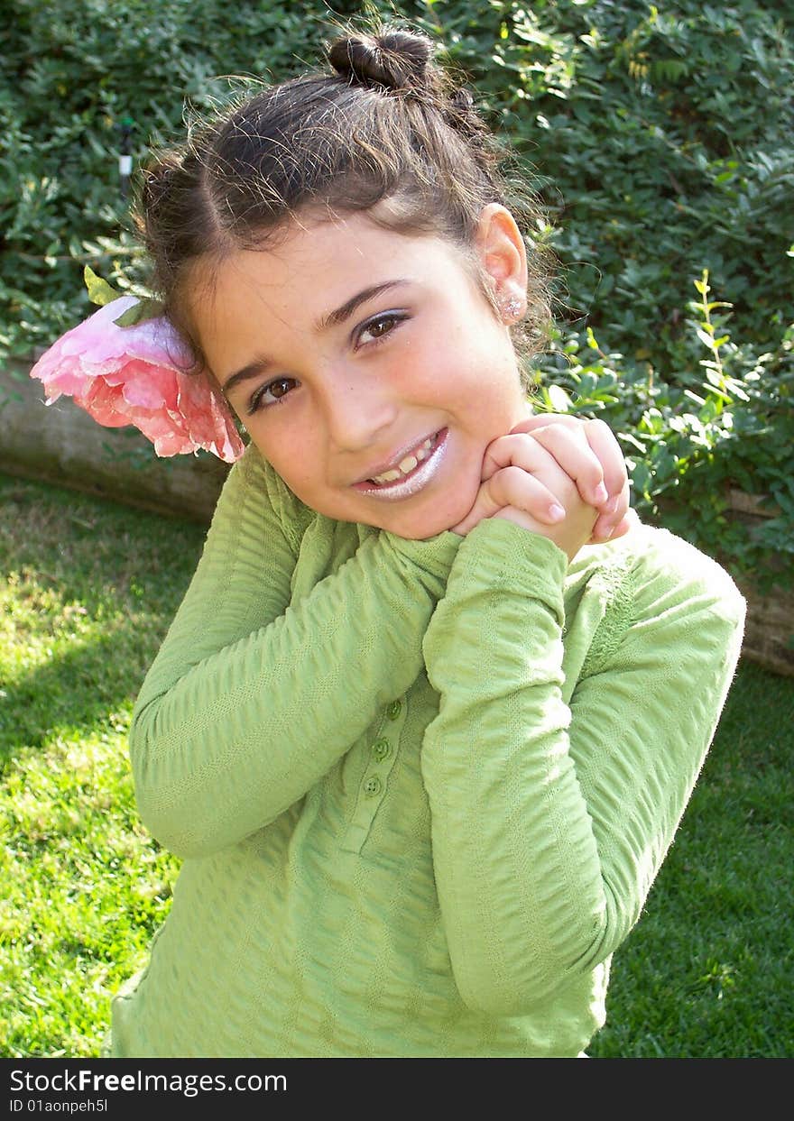 This is a picture of a little girl posing for a picture with a flower in her hair. This is a picture of a little girl posing for a picture with a flower in her hair