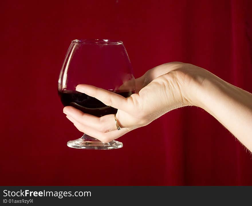 Woman's hand holding a glass of red wine