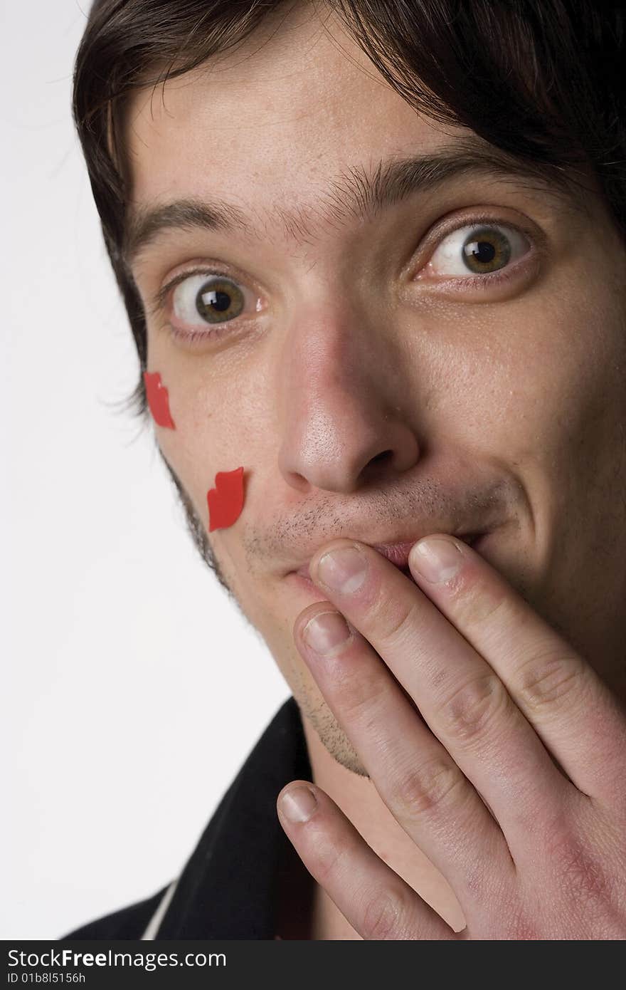 Portrait of a young man on a white background with novelty kisses on his face