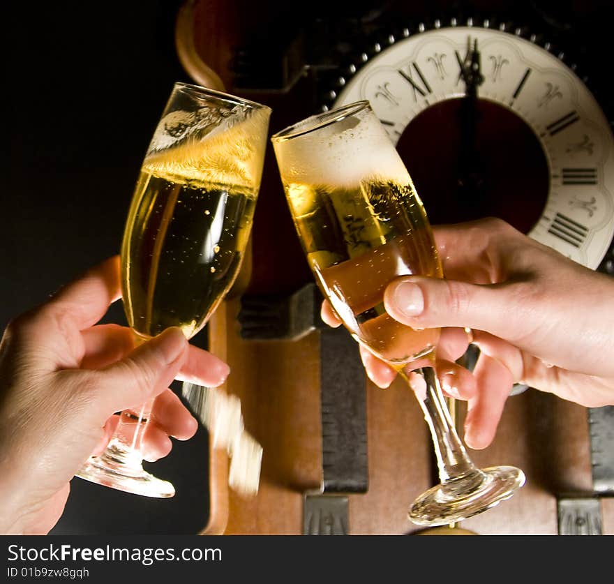 Champagne toast at midnight with clock in the background