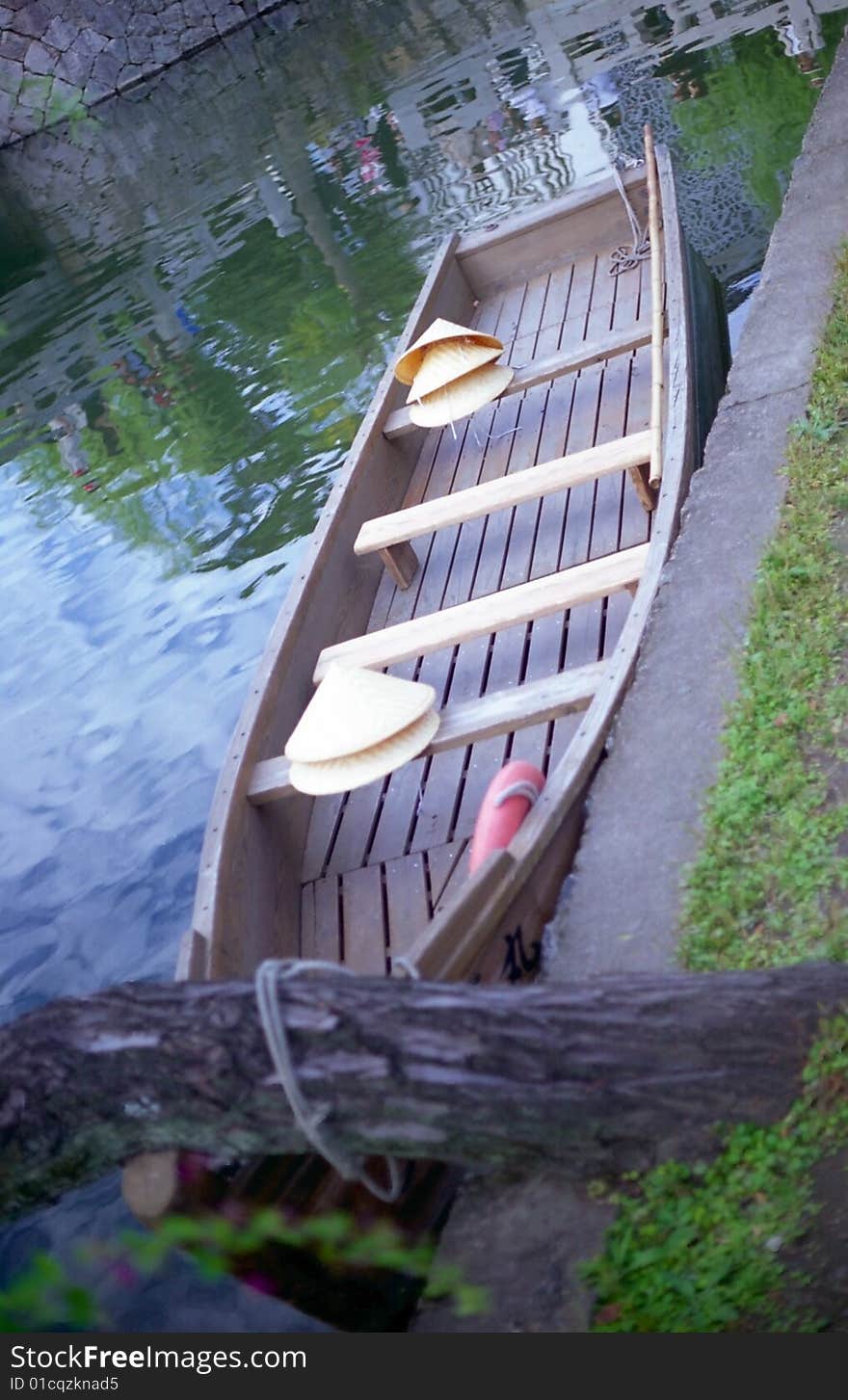 Empty boat with straw hats waiting for tourists in a canal in Kurashiki, Japan. Empty boat with straw hats waiting for tourists in a canal in Kurashiki, Japan