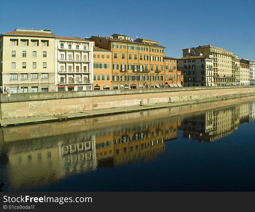 Travel in Italy: Pisa, landscape with the reflected houses in the water at the sunset. Travel in Italy: Pisa, landscape with the reflected houses in the water at the sunset