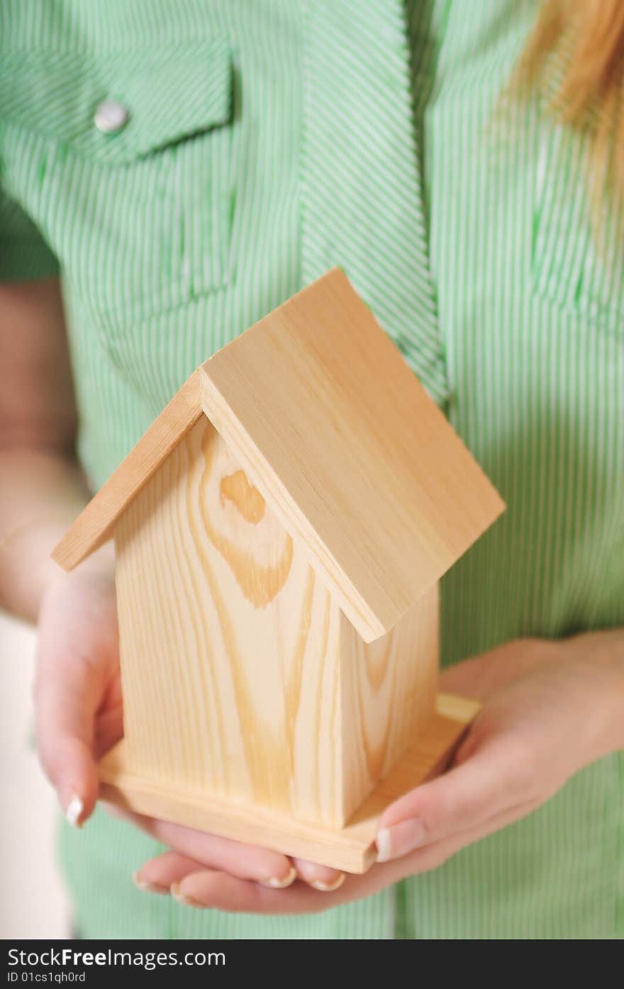 Little home in the hands of young woman, on the white background