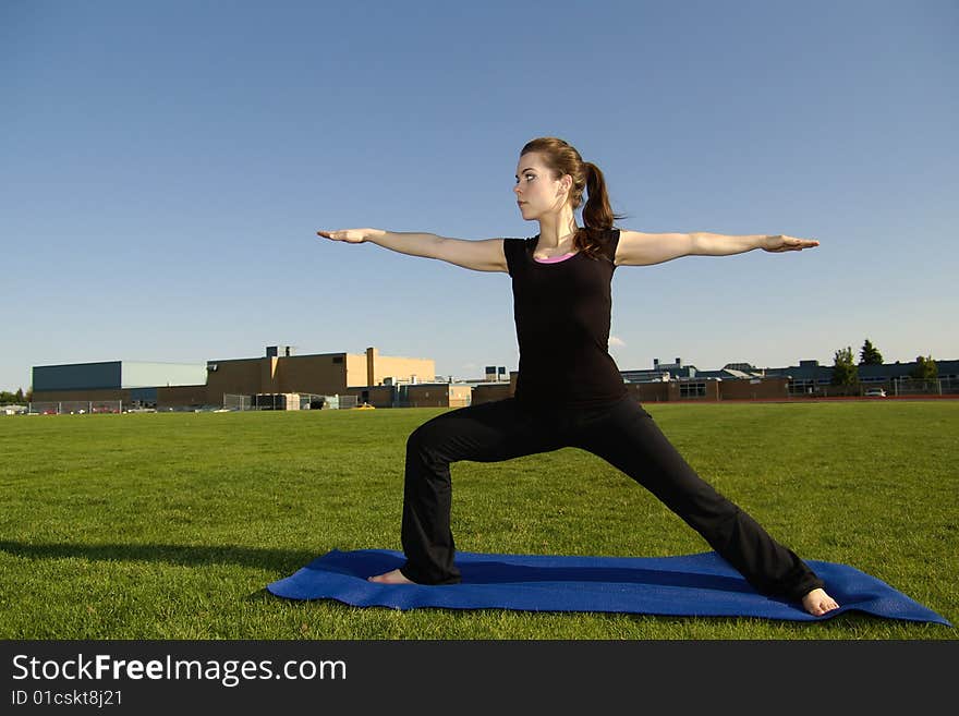 A young adult does yoga poses outside. A young adult does yoga poses outside