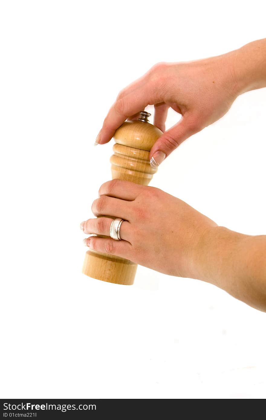 Using a pepper-mill on a white background. Using a pepper-mill on a white background.