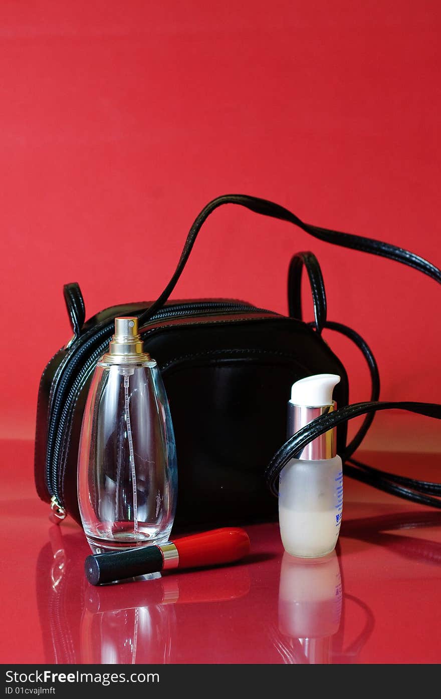 Cosmetics and perfume in a black purse