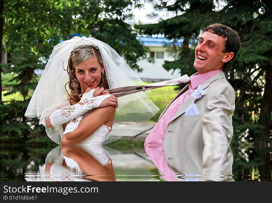 The bride pulls the groom for a tie. The bride pulls the groom for a tie