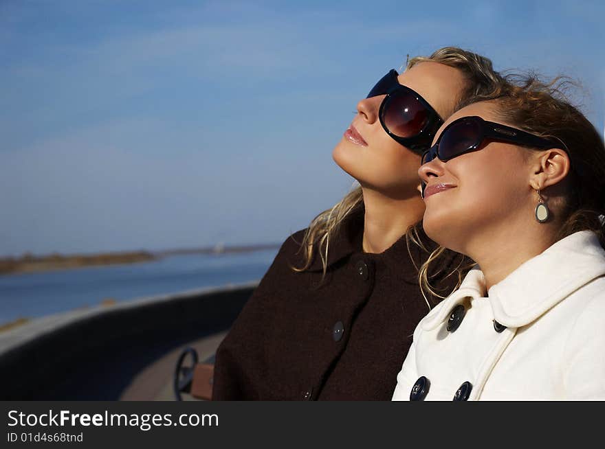 Two beautiful girl sit on лавочке in the autumn afternoon. Two beautiful girl sit on лавочке in the autumn afternoon