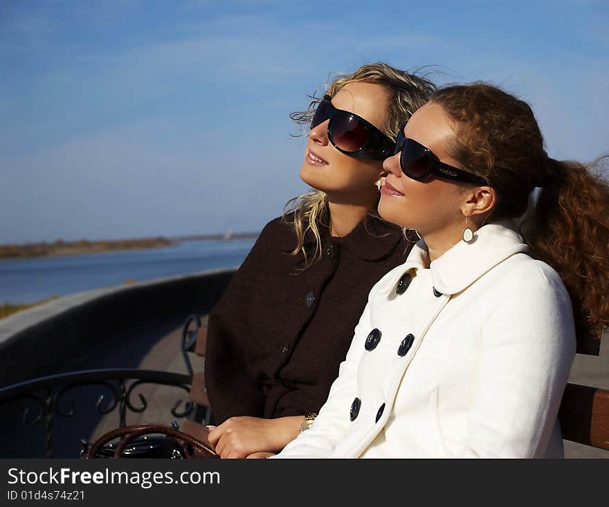 Two beautiful girl sit on лавочке in the autumn afternoon. Two beautiful girl sit on лавочке in the autumn afternoon