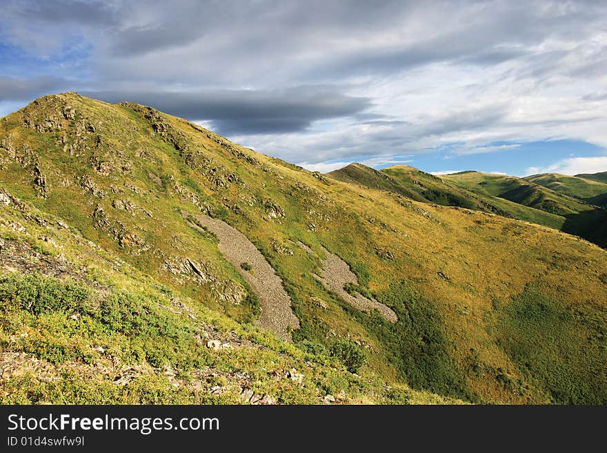 Mountain with rocks under clody sky