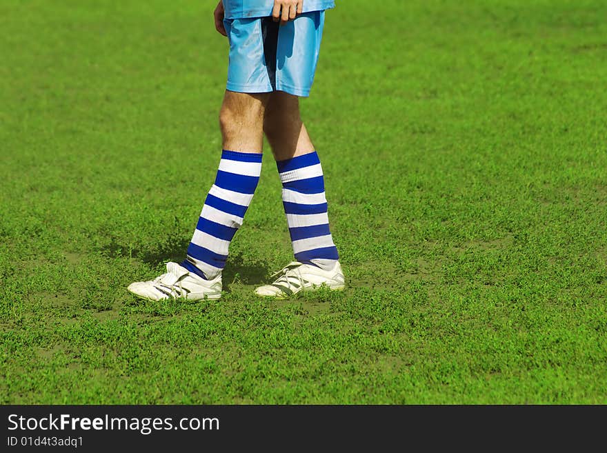 Soccer player's legs on green field