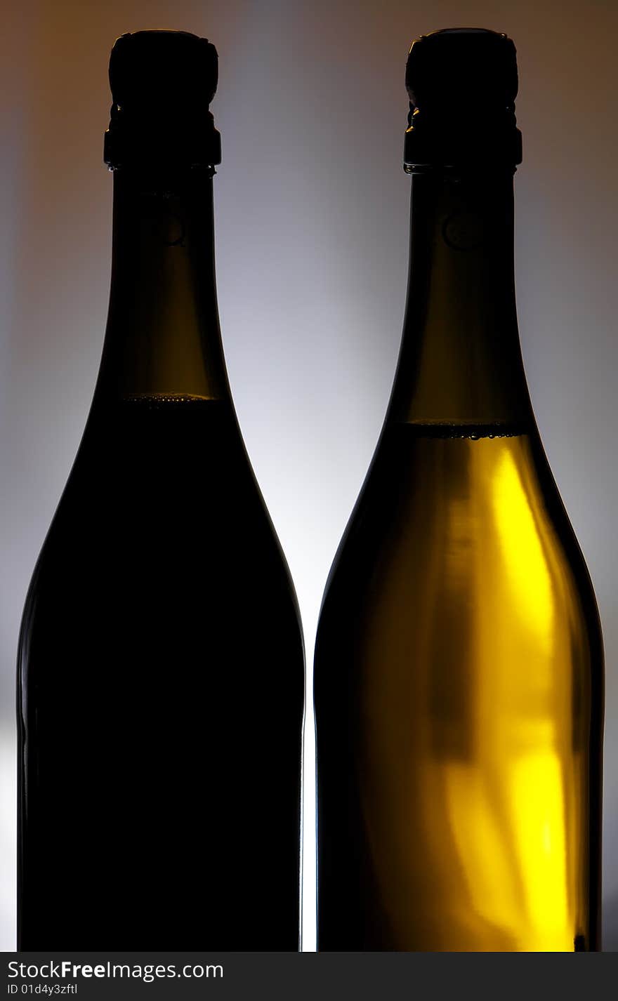 Champagne bottles against background with light spot on it. Champagne bottles against background with light spot on it.