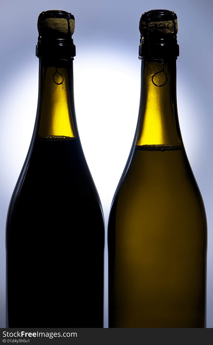 Champagne bottles against background with light spot on it. Champagne bottles against background with light spot on it.