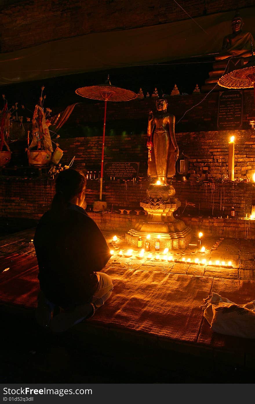 A girl pays respect to the buddha statue. A girl pays respect to the buddha statue.