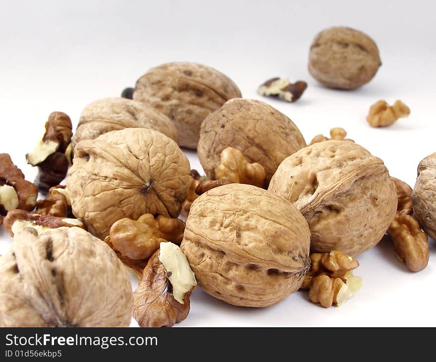 Whole and split walnuts on a white background