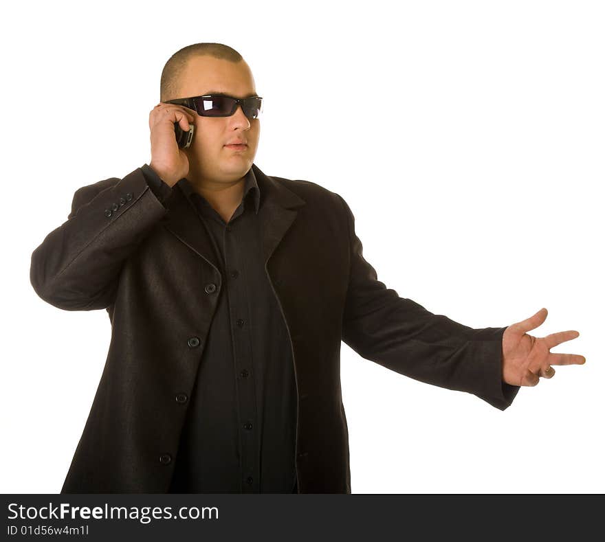 Man in black suit in sun glasses talking on the mobile phone. Isolated on white background