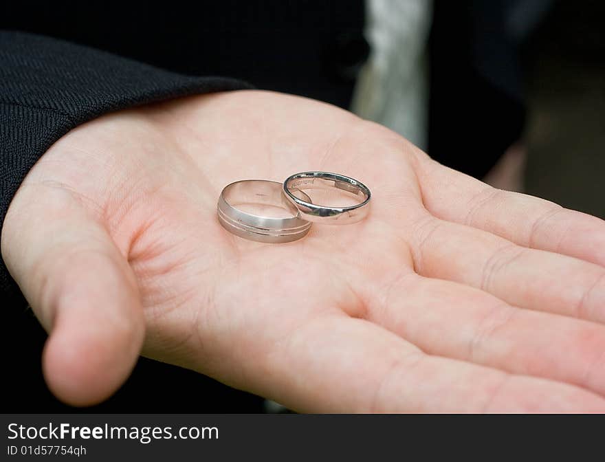 Silver wedding rings in the safe hands of the best man. Silver wedding rings in the safe hands of the best man