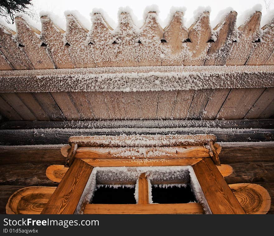 Wooden house covered with snow