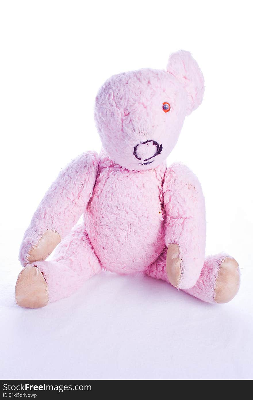 Old and worn pink teddy bear isolated on white