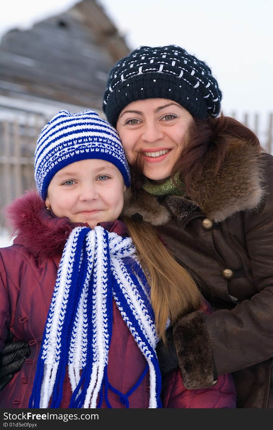 Woman with a young girl in a cap and scarf