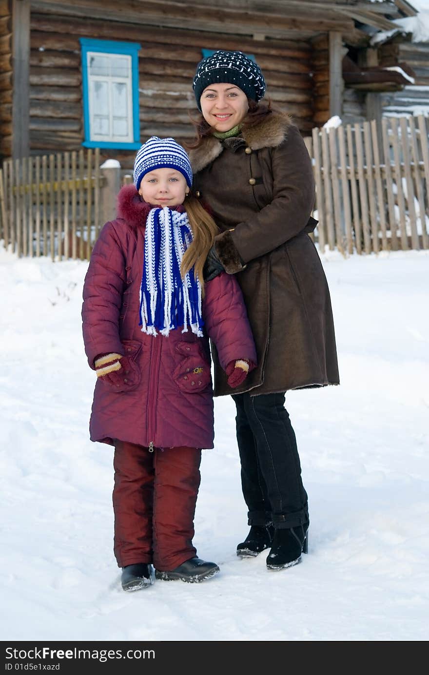 Woman with a young girl in a cap and scarf