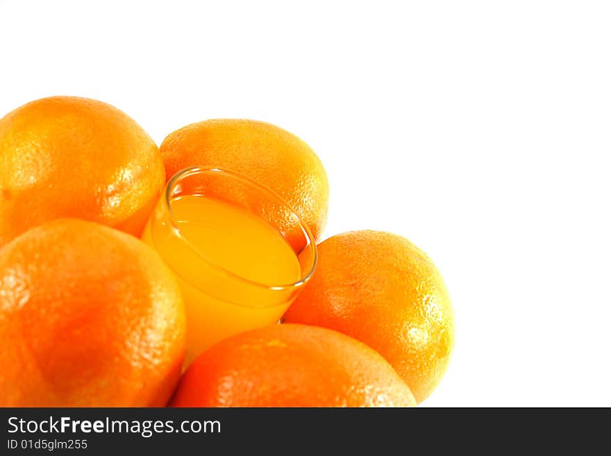 Orange juice in a glass and oranges on a white background