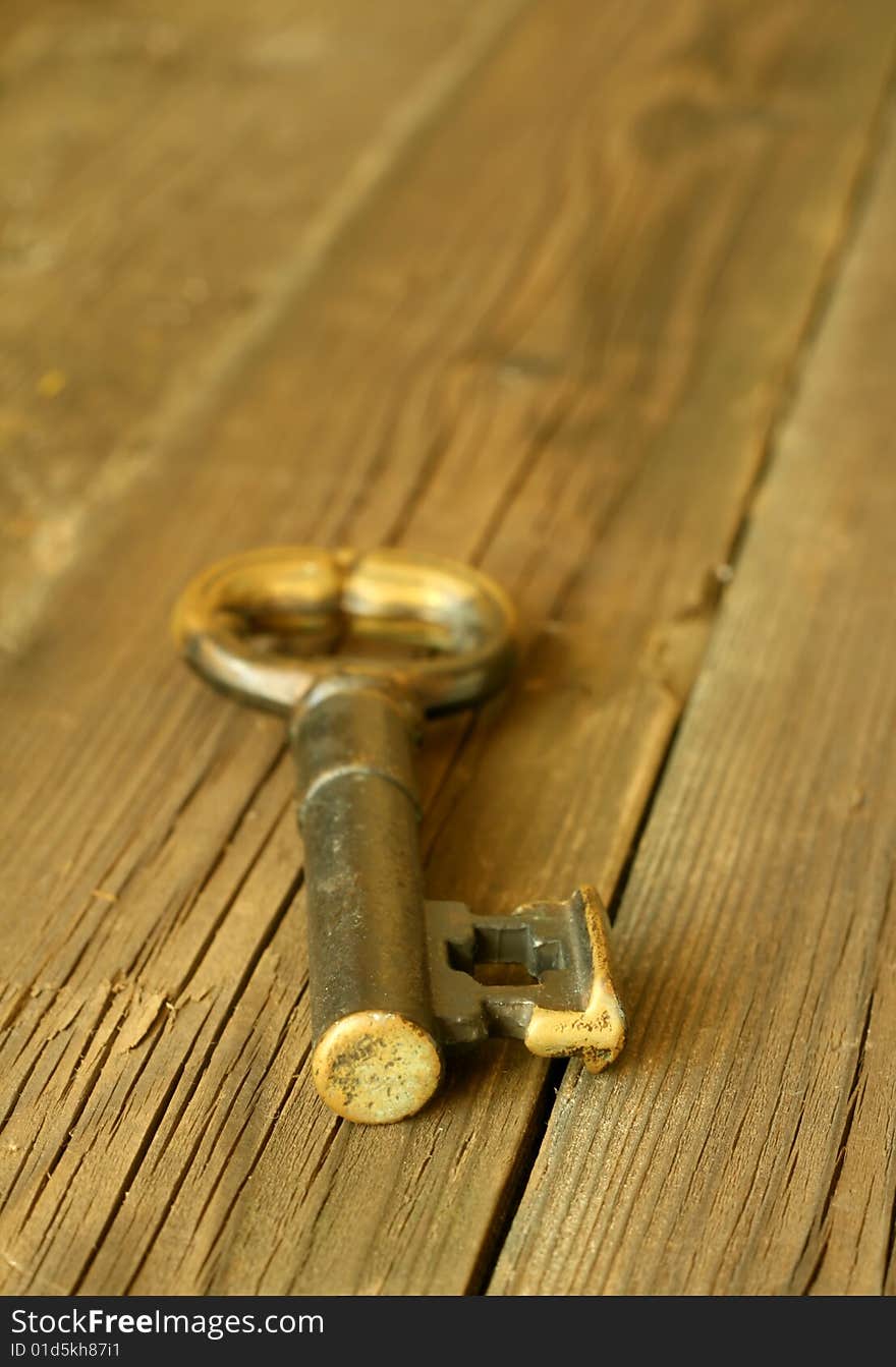 Old metal key on wooden