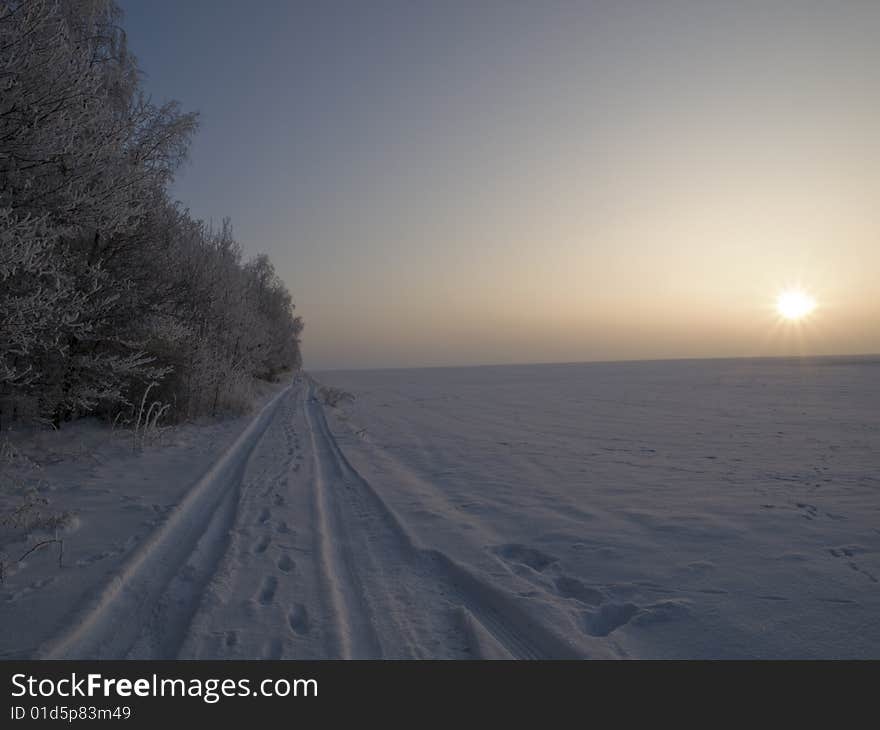 Image of the tracks in the snow takeń during winter sunset