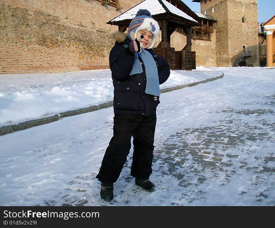 Portrait of child on a background an old castle in winter time