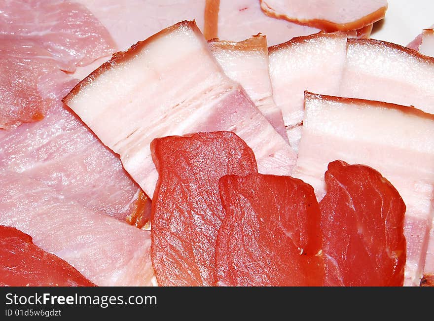 The smoked meat and the fat are cut by slices. The smoked meat and the fat are cut by slices