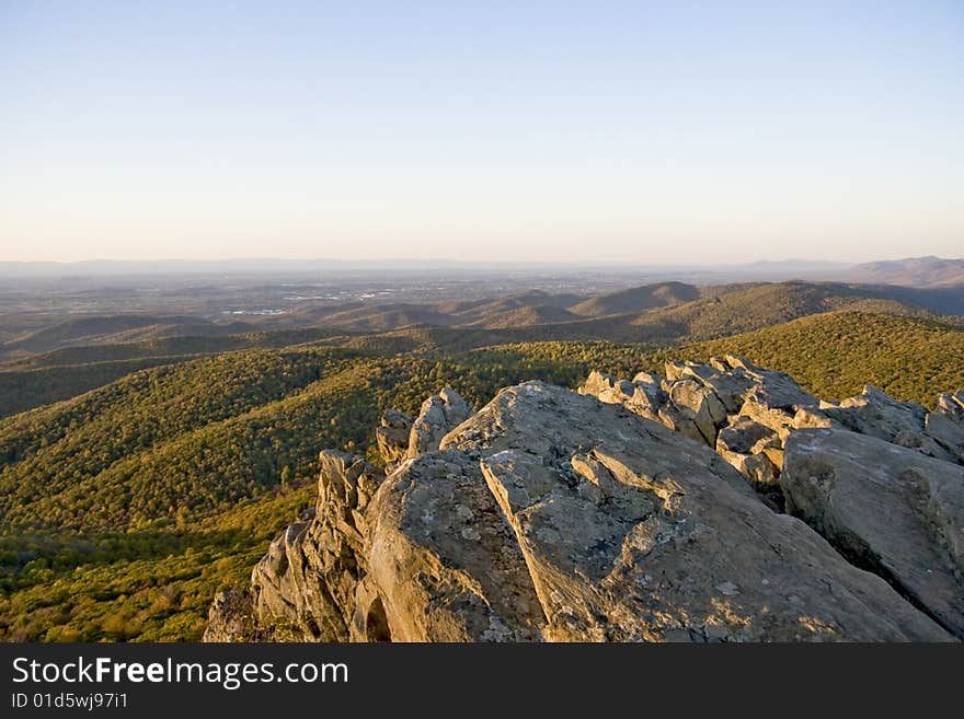 Rock structure over looking autumn mountain range as the sun sets. Rock structure over looking autumn mountain range as the sun sets.