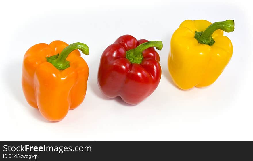 Three colored peppers isolated on white