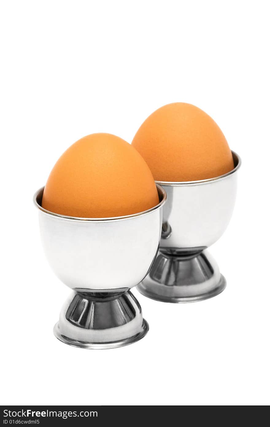 Eggs in metal eggcup on a white background