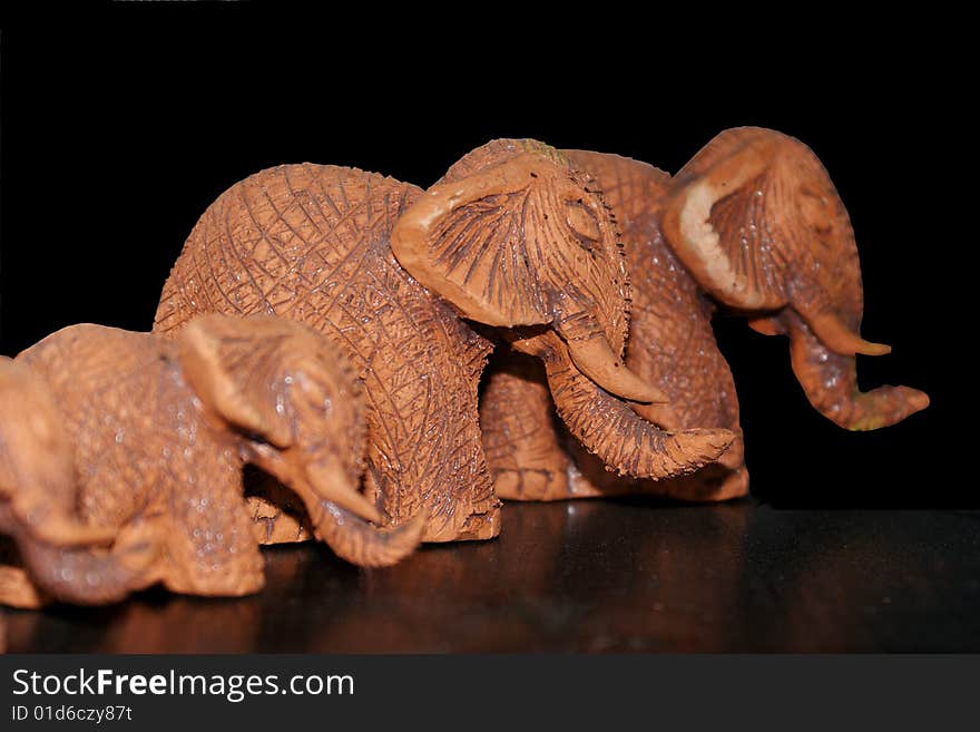 3 Brown clay elephants on a black background