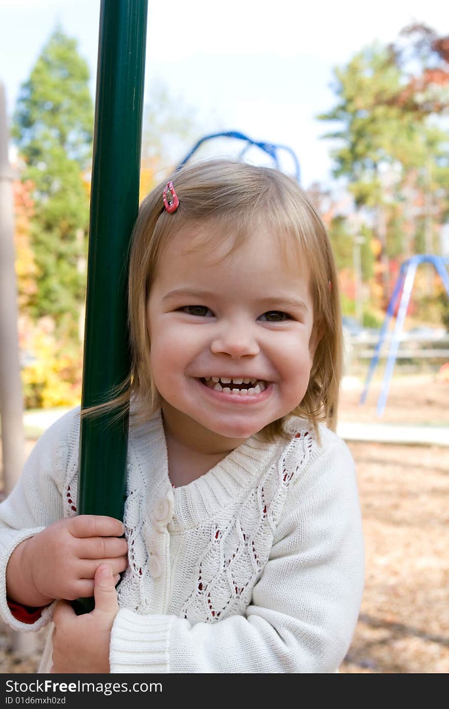 A little girl on the playground on an autumn day