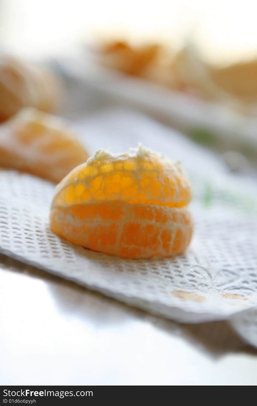 Close up shot of a peeled clementine orange on a napkin ready to eat.