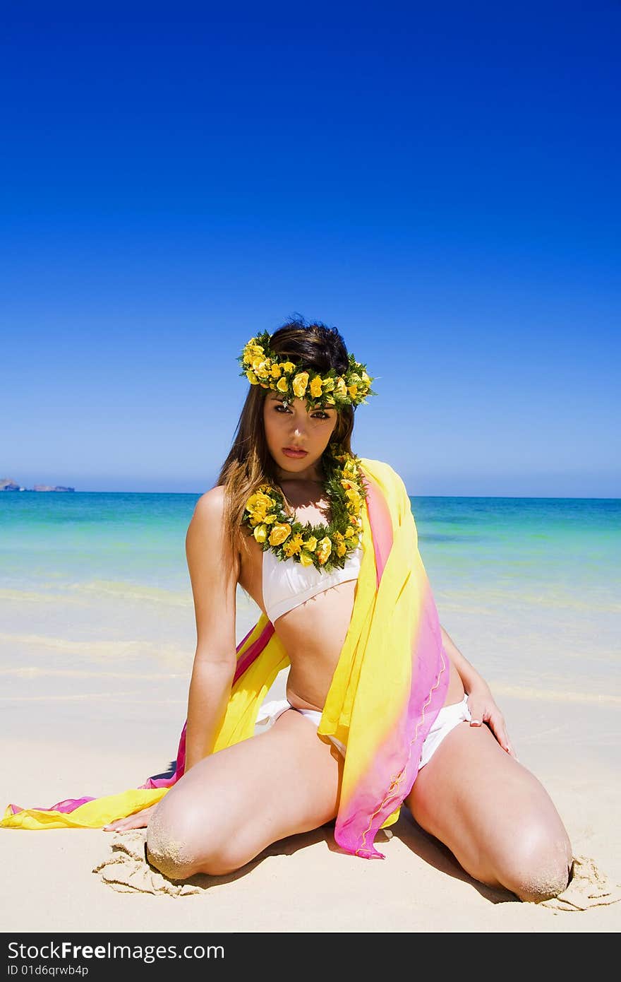 A beautiful young woman in a white bikini at a tropical beach in Hawaii