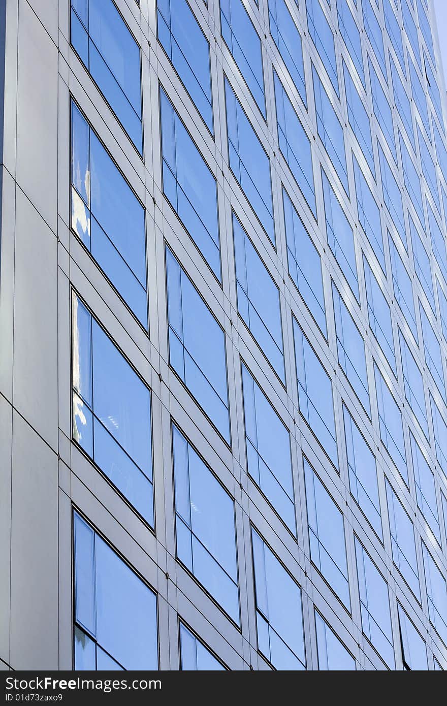 Windows by modern building in blue sky