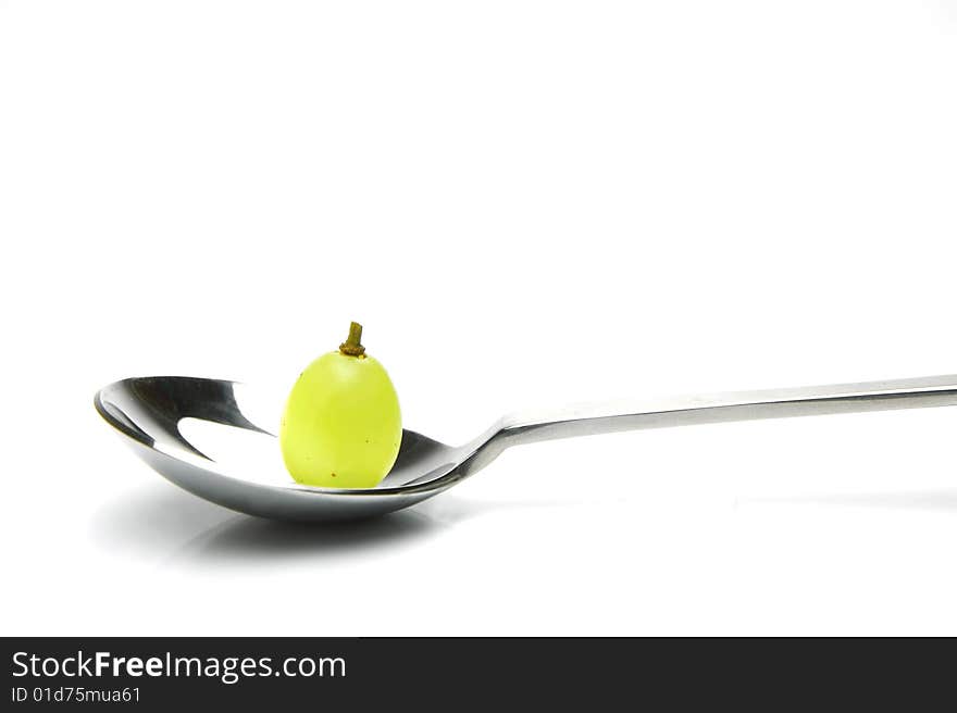 Grapes on a spoon isolated against a white background. Grapes on a spoon isolated against a white background