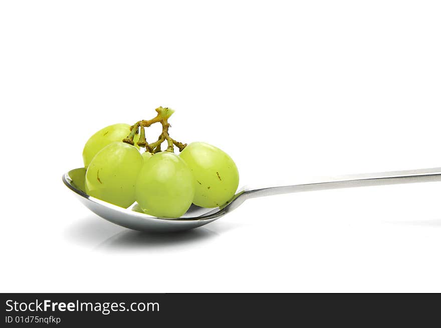 Grapes on a spoon isolated against a white background. Grapes on a spoon isolated against a white background