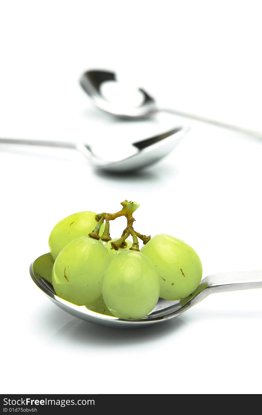 Grapes on a spoon isolated against a white background. Grapes on a spoon isolated against a white background