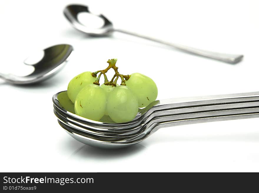 Grapes on a spoon isolated against a white background. Grapes on a spoon isolated against a white background