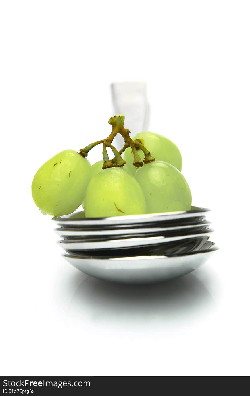 Grapes on a spoon isolated against a white background. Grapes on a spoon isolated against a white background