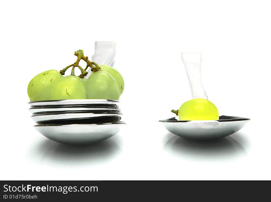 Grapes on a spoon isolated against a white background. Grapes on a spoon isolated against a white background