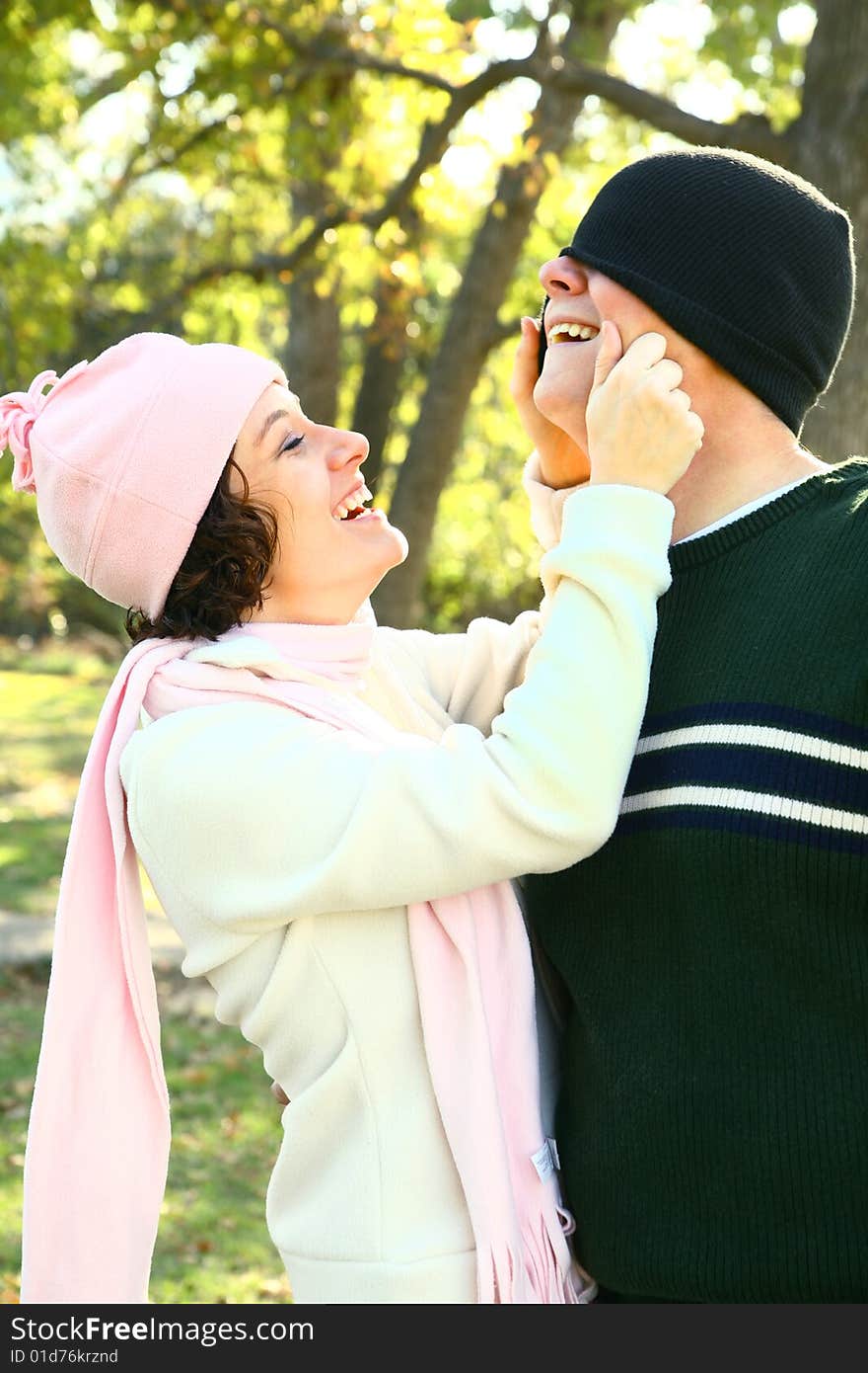 Young adult embracing while walking in the park. Young adult embracing while walking in the park