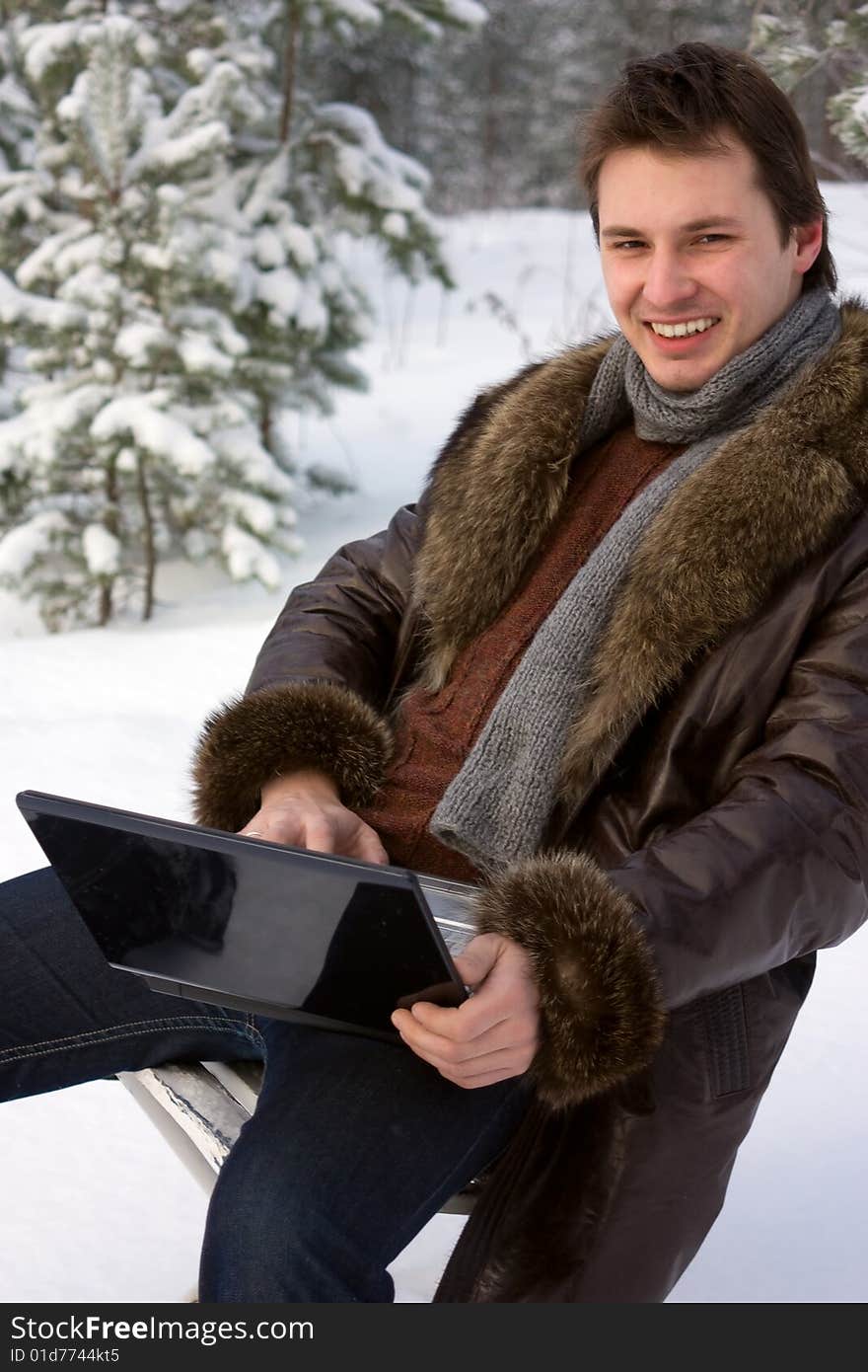 Young smiling man with laptop outdoors. Young smiling man with laptop outdoors