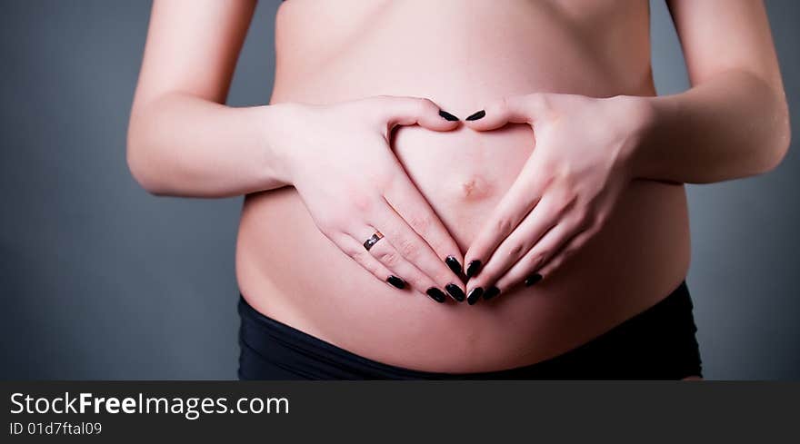 Close-up of pregnant woman holding her belly