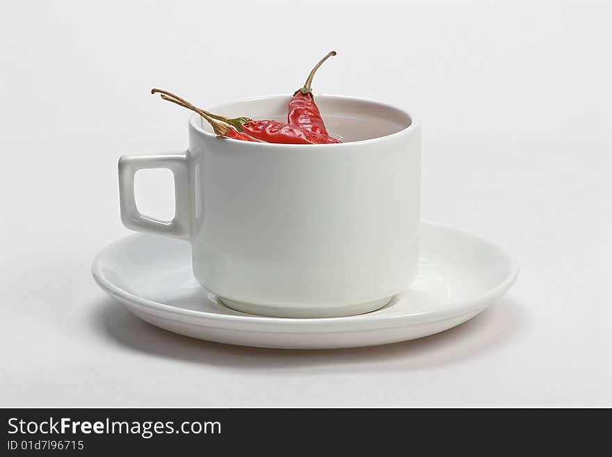 Macro shot of red hot chili peppers with white cup plate. Macro shot of red hot chili peppers with white cup plate