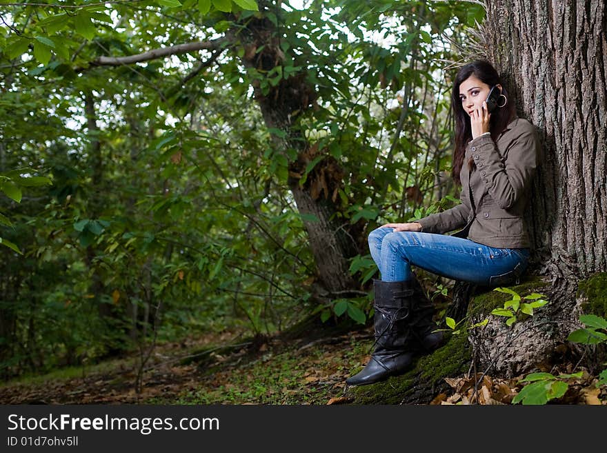 Young woman talking by phone on deep forest. Young woman talking by phone on deep forest