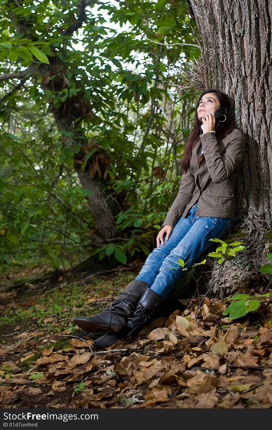 Young woman talking by phone on deep forest. Young woman talking by phone on deep forest